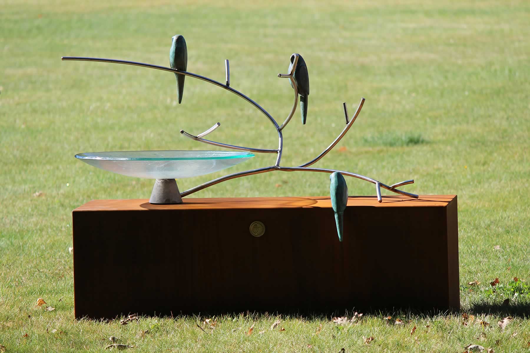 Glass birdbath on corten plinth, stainless steel branch, bronze birds