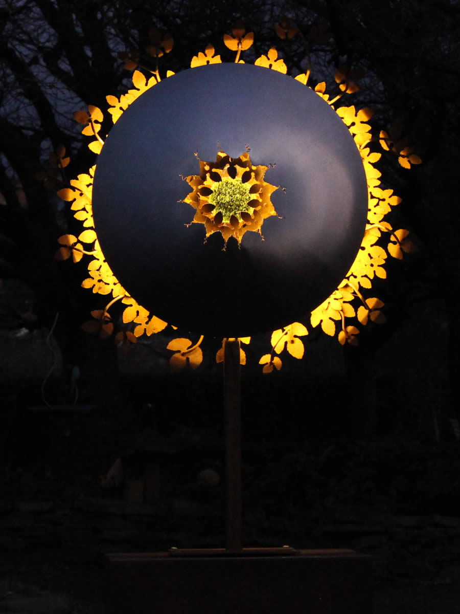 1.3m diameter, 2m tall, stainless steel, corten steel, LED and a tuft of faux turf, also available wall hung